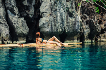 Beautiful woman relaxing on raft in tropical lagoon