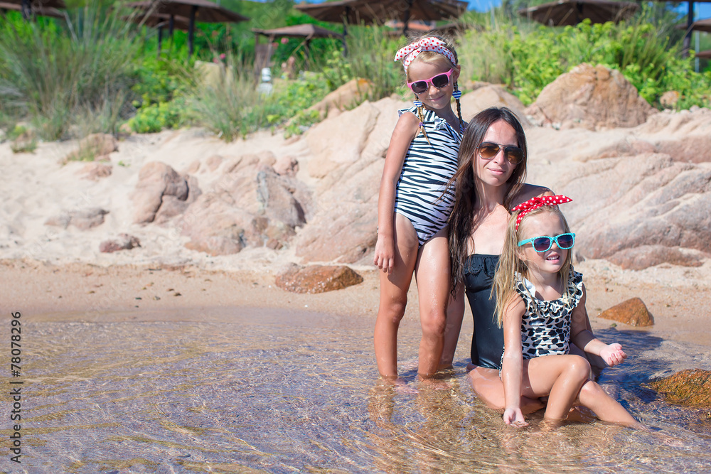 Wall mural little adorable girls and happy mother during beach vacation