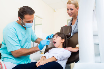Kleines Mädchen mit ihrer Mutter beim Zahnarzt