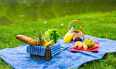 Foto op Canvas Picknickmand met fruit, brood en fles witte wijn © travnikovstudio
