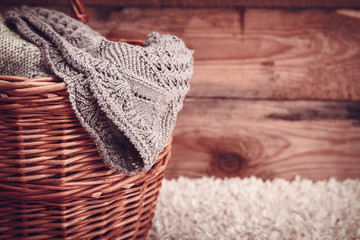 knitted fabric in a basket on a wooden background.vintage toning