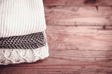 stack of sweaters on a wooden background. vintage toning