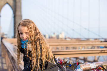 Obraz na płótnie Canvas Adorable little girl sitting at Brooklyn Bridge