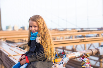 Obraz na płótnie Canvas Adorable little girl sitting at Brooklyn Bridge