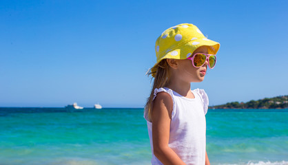 Fototapeta na wymiar Adorable little girl at white beach during tropical vacation