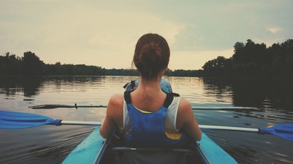 Rowing on kayak down the river on sunset - obrazy, fototapety, plakaty
