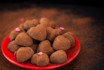Heart shaped chocolate truffles on red plate