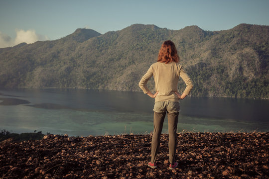 Woman standing on mountain overlooking bay