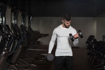 Young Man Exercising Biceps With Dumbbells