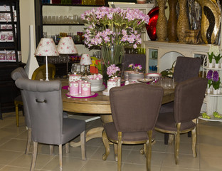 table chairs vase of flowers