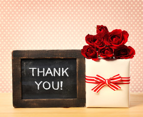 Thank you message on chalkboard with roses and present box