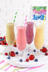 Delicious berry cocktails on table on brick wall background