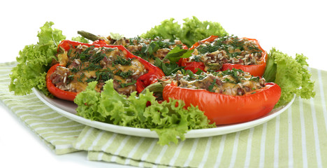 Stuffed red peppers on plate on napkin isolated on white