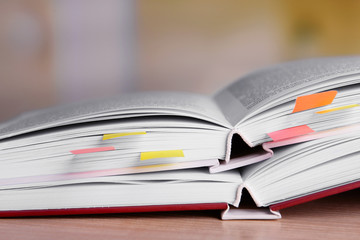 Books with bookmarks on table on bright background