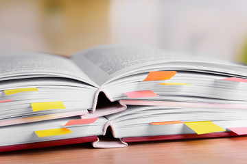 Books with bookmarks on table on bright background