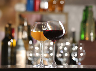 Two glasses of wine with bar on background