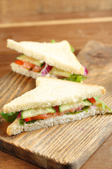 Club sandwich with salmon on wooden background