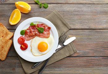 Bacon and eggs on rustic wooden planks background
