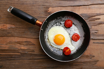 Bacon and eggs on rustic wooden planks background