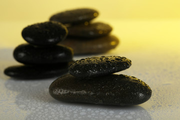 Spa stones with water drops on light background
