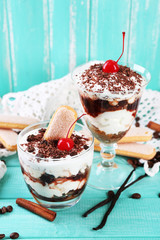 Tasty tiramisu dessert in glasses, on color wooden background