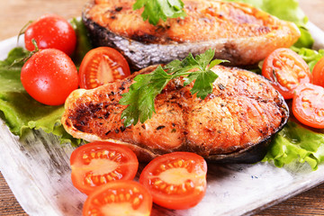 Tasty baked fish on plate on table close-up