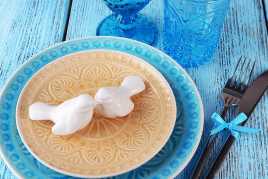 Empty colorful plate, glasses and silverware set on wooden