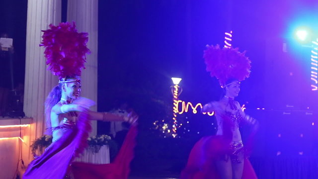 two girls wearing red theatrical costumes are dancing	
