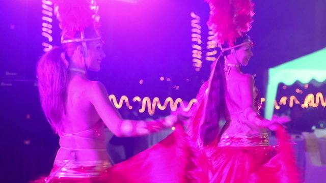 two girls wearing red theatrical costumes are dancing	