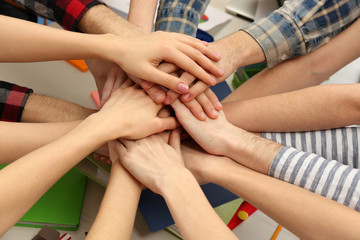 Fototapeta premium United hands of business team on workspace background top view