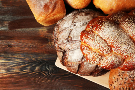 Fresh breads with bun on wooden table close up