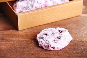 Pink cookies in paper box on table close-up