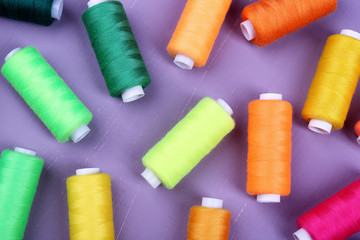Multicolor sewing threads on wooden background