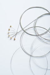 Full set of electric guitar strings on a white surface