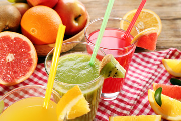 Fresh juices with fruits on wooden table