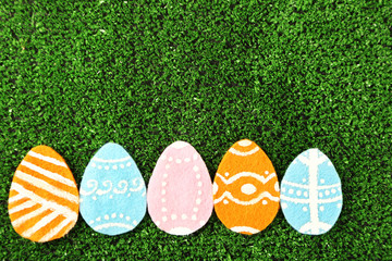 Colorful felt Easter eggs on grass close-up