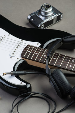 Black and white guitar with vintage photo camera and headphones