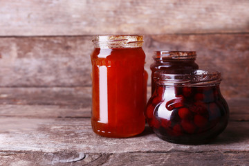 Homemade jars of fruits jam on rustic wooden background