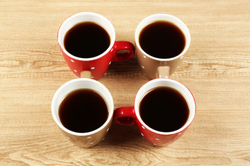 Cups of coffee on wooden table background