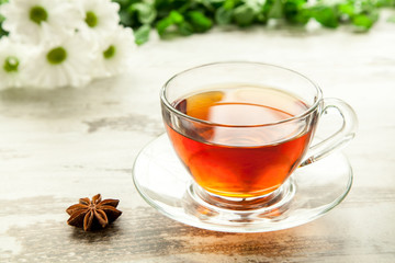Glass cup of tea on a wooden table.