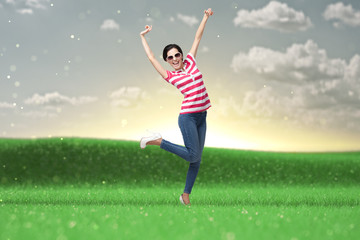 Fototapeta na wymiar Happy dancing teenager with arms upon the meadow
