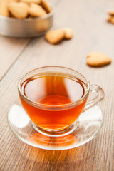 Glass cup of tea on a wooden table.