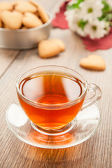 Glass cup of tea on a wooden table.