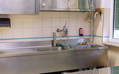 Fototapeta na wymiar sink and the Workbench in an industrial kitchen in the school ca