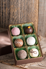 Pralinen in Verpackung auf Holzhintergrund