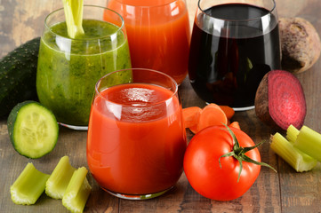 Glasses with fresh organic vegetable juices on wooden table