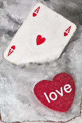 Red heart with ace of hearts in the snow