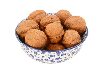 Walnuts in shells, in a blue and white china bowl