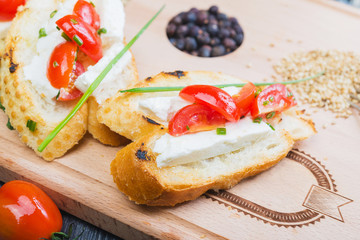 traditional Spanish tapas with cheese and tomatoes on a wooden