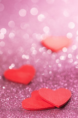 Red hearts over abstract glitter background